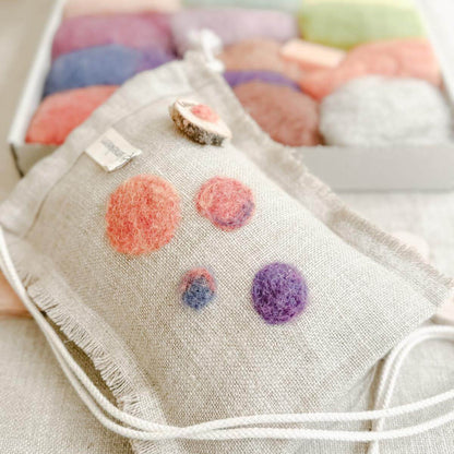 Farbiges Filzmuster in Lila und Orange – Trockenfilzen auf Leinen.