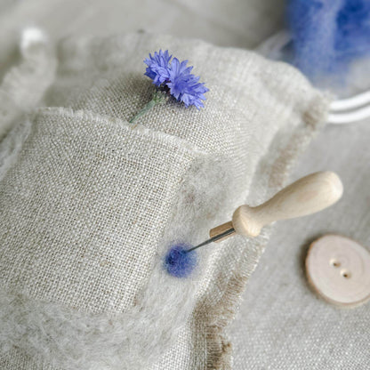 Schurwolle in Blau wird auf Leinen gefilzt – Kreativset aus Naturmaterialien.